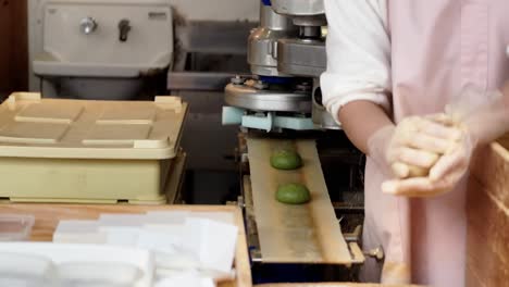 hands-in-making-green-mochi-sticky-glutinous-in-a-factory