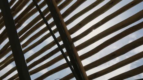 Sun-shining-through-bamboo-roof-and-wooden-slats-on-old-building