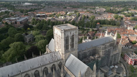 Pullback-Aerial-Drone-Shot-Pulling-Back-From-Closeup-Over-York-Minster-Cathedral-with-Green-Trees-and-Old-Buildings-on-Sunny-and-Cloudy-Day-North-Yorkshire-United-Kingdom