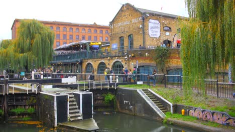 Shot-of-Camden-market-beside-Camden-Lock-with-locals-passing-by-in-London,-UK-on-a-cloudy-winter-day