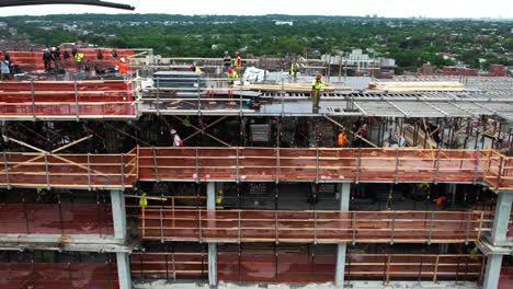 Aerial-view-of-contractors-at-work-on-a-tall-building-constrution-site,-in-New-York,-USA