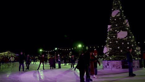 People-Skating-Around-Christmas-Tree-At-Glide-Battersea-Ice-Rink-At-Night