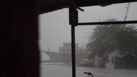 Blick-Durch-Das-Fenster-Auf-Starken-Regen,-Der-Am-Bewölkten-Tag-Im-Fischerhafen-Von-Gwadar-Fällt