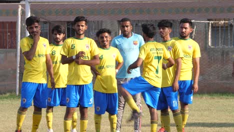 Local-Football-Team-In-Yellow-Tops-Standing-Around-Before-Kick-Off-In-Karachi,-Pakistan