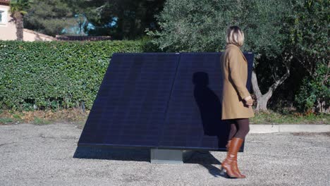 slow-motion-dolly-shot-of-a-woman-walking-around-a-delivered-solar-panel