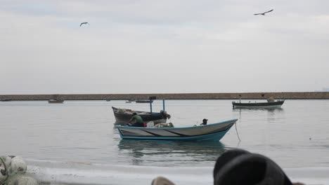 Dolly-Left-Reveal-Of-Small-Fishing-Boat-Going-Past-With-Seagulls-Flying-Overhead-At-Gwadar-On-Coast-Of-Balochistan