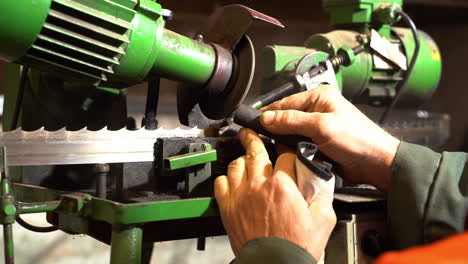 Engineer-doing-maintenance-on-electric-band-saw-blade-sharpener
