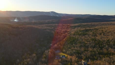 A-drone-shot-in-Vermont-of-the-winter-and-ski-mountains-in-the-background-during-sunset