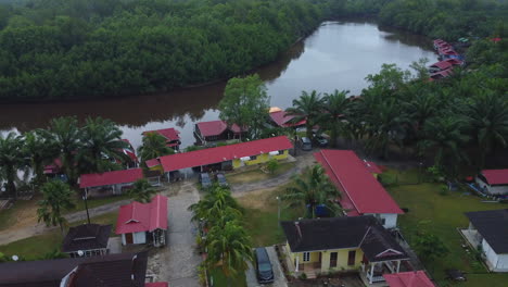Drone-view-of-houses-village-near-river-in-Rompin-Pahang,-Malaysia