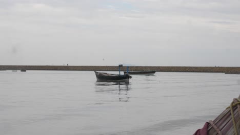 Dolly-Left-Reveal-Of-Small-Empty-Boat-Floating-In-Harbour-Waters-In-Gwadar-On-Coast-Of-Balochistan