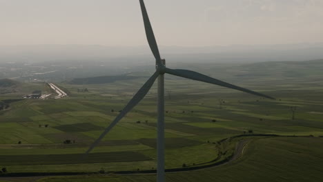 Rotating-wind-turbine-generator-blades-above-Gori-farm-fields,-Georgia