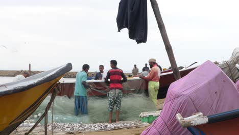 Local-Fisherman-Sorting-Fishing-Net-In-Gwadar-Beside-Boat-In-Gwadar-On-Coast-Of-Balochistan