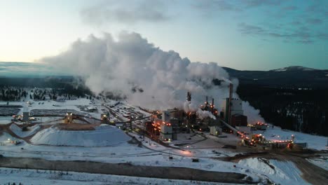 Wintertime-Pollution-at-Pulp-Mill-in-Cranbrook,-British-Columbia:-Aerial-View-of-Industrial-Facility-and-Machinery-Turning-Timber-into-Wood-Pulp