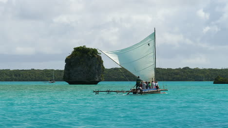 Tourists-at-the-Isle-of-Pines-sailing-on-a-traditional-outrigger-canoe-at-Upi-Bay