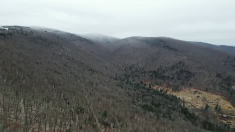 A-drone-shot-of-a-snow-cloud-snowing-in-the-mountains-in-Vermont,-New-England