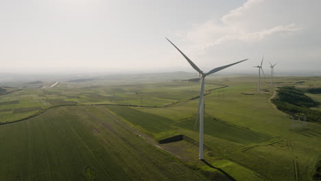 Wind-generator-turbines-slowly-rotating-above-fields-of-Gori,-Georgia