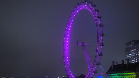 Icónico-Ojo-De-Londres-Iluminado-Con-Luces-De-Neón-Púrpura-En-La-Orilla-Del-Río-Támesis-Por-La-Noche-En-Londres,-Reino-Unido