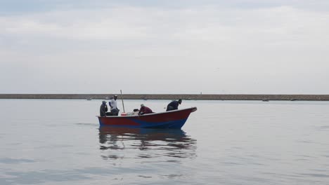 Vista-De-Un-Pequeño-Barco-De-Pesca-Con-Pescadores-Preparándose-Para-Atracar-En-Gwadar-En-La-Costa-De-Baluchistán