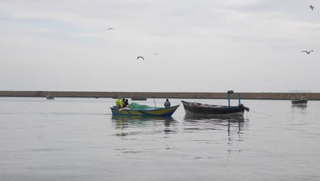 Kleines-Fischerboot,-Das-An-Gwadar-An-Der-Küste-Von-Belutschistan-Vorbeifliegt,-Mit-Möwen,-Die-über-Uns-Fliegen