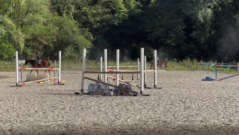 Outdoor-school-with-obstacles-for-equestrianism-training-and-young-people-riding-horses