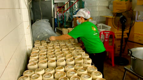 Backroom-of-coco-jelly-store-with-woman-preparing-the-traditional-street-food-pouring-coconut-water-jelly-into-coconut-shell