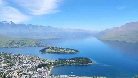 Queenstown-New-Zealand-city-center,-parks-and-Lake-Wakatipu-in-beautiful-lake-drone-shot