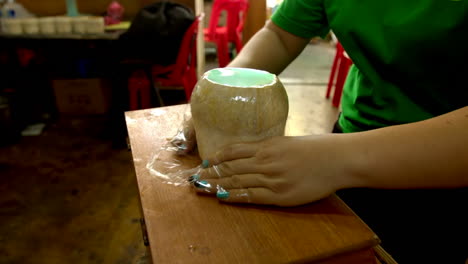 Unrecognizable-woman-wrapping-coconut-filled-with-coco-jelly,-traditional-thai-street-food-made-with-coconut-pulp-and-water-jelly