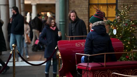 Ein-Kind,-Das-Vor-Weihnachten-In-Covent-Garden,-London,-Vereinigtes-Königreich,-Auf-Dem-Weihnachtsmannwagen-Reitet