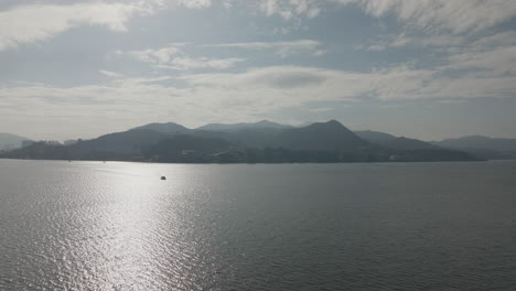 Toma-De-Drones-Del-Vasto-Océano-Con-Montañas-En-Hong-Kong