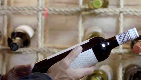Close-up-of-a-person-looking-at-a-selected-bottle-of-wine-in-slow-motion