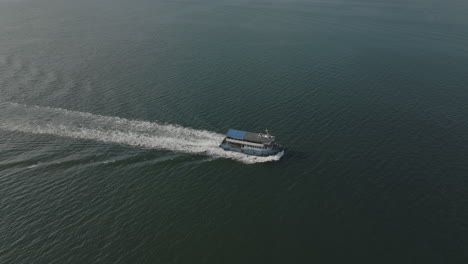 Toma-Aérea-De-Drones-De-Un-Barco-Turístico-En-El-Agua-En-La-Ciudad-De-Hong-Kong,-China