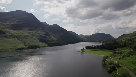 Drone-shot-flying-backward-above-Crummock-Water-on-a-sunny-day,-Lake-District,-Cumbria,-UK