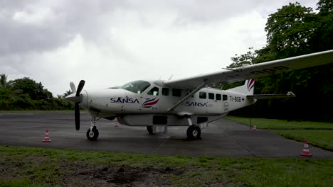 Cessna-208B-Grand-Caravan-EX-from-Sansa-Airlines-parked-at-runway,-Locked-handheld-shot
