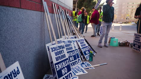 Picket-Signs-Leaning-Against-a-Wall-with-UC-Academic-Workers-on-Strike-in-the-Background-at-UCLA