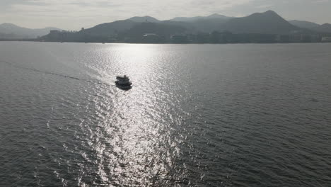 Drohnenaufnahme-Eines-Tourismusboots-Auf-Dem-Wasser-In-Der-Stadt-In-Hongkong,-China