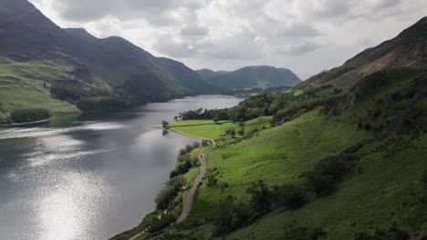 Drone-shot-flying-backwards-along-the-hills-next-to-Crummock-Water-on-a-sunny-day,-Lake-District,-Cumbria,-UK