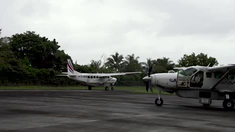 Cessna-208b-Grand-Caravan-Ex-Avión-Monomotor-Despegando-Del-Aeropuerto-Rural-Con-Otro-Estacionado-Cerca,-Sansa-Airlines,-Sigue-El-Tiro-Derecho