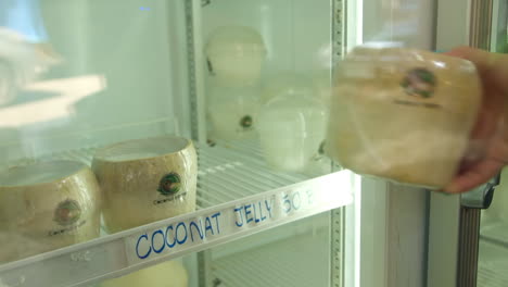 Storing-fresh-handmade-coco-jelly,-traditional-thai-street-food,-in-supermarket-fridge-for-sale