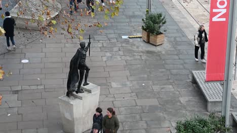 Family-looking-at-the-statue-outside-of-the-National-Theatre,-London,-United-Kingdom