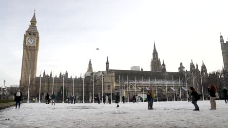 Tourists-Enjoying-Snow-Covered-Snow-Covered-Parliament-Square-Gardens-With-Big-Ben-And-Houses-Of-Parliament-In-The-Background