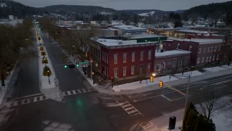 Aerial-descending-shot-with-tilt-up-towards-building-on-corner-of-square-of-small-town-in-America