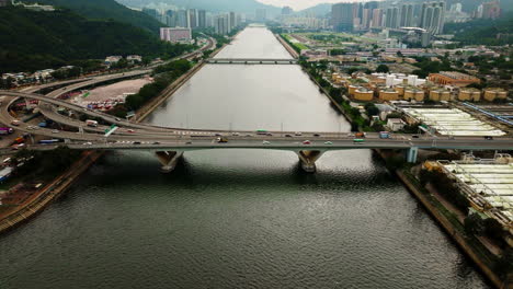 Disparo-De-Drones-De-Vehículos-De-Tráfico-Conduciendo-En-La-Carretera-Sobre-Un-Amplio-Puente-Fluvial,-China