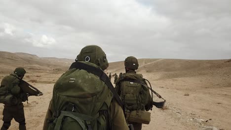 Aufnahme-Von-IDF-Soldatentruppen,-Die-Während-Der-Kriegsspiele-In-Der-Wüste-Hand-In-Hand-Gehen