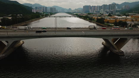 Cars-driving-on-highway-over-a-wide-waterway-bridge-in-HongKong