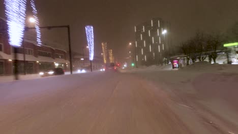 POV-driving-shot-in-downtown-Helsinki-with-bright-Christmas-lights-on-display