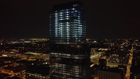 AERIAL:-Drone-shot-of-a-lit-building-in-the-chicago-skyline-at-night