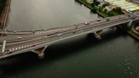 Traffic-cars-driving-on-highway-over-a-wide-waterway-bridge-in-hongkong,-China