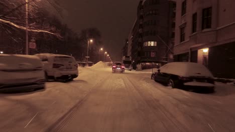 POV-shot-driving-along-a-street-with-snow-covered-cars-in-downtown-Helsinki