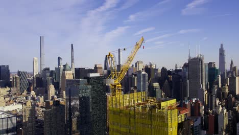 Aerial-view-around-a-crane-at-a-skyscraper-under-construction-in-Hudson-Yards,-New-York-city-USA---orbit,-drone-shot