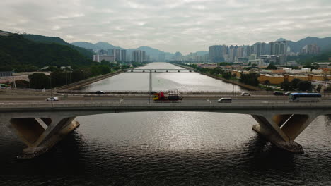 Luftdrohne-Schoss-Autos,-Die-Auf-Der-Autobahn-über-Eine-Breite-Wasserstraßenbrücke-Fahren,-Hongkong